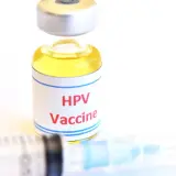 Szczepionka HPV w fiolce obok strzykawki. Zastanawiasz się nad hpv szczepionka cena?