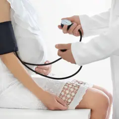 Lekarz mierzy ciśnienie ciężarnej pacjentce, monitorując jej stan przedrzucawkowy.