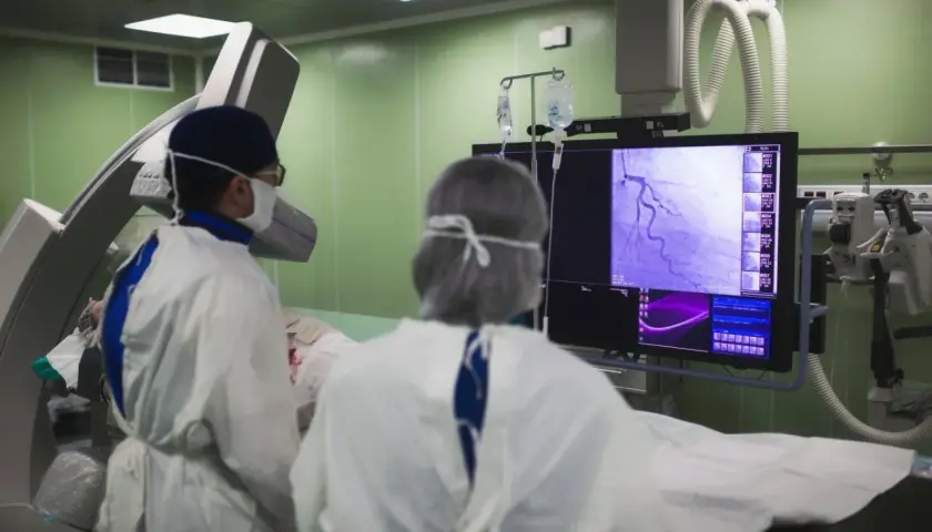 Lekarze analizują obraz z koronarografii na monitorze, oceniając stan naczyń wieńcowych.
