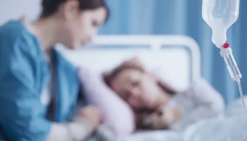 Pielęgniarka czuwa przy dziecku w szpitalu, które walczy z chorobą DMD. Kroplówka podtrzymuje życie.